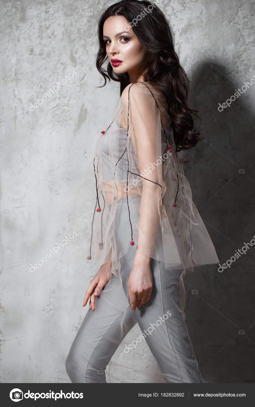 Beautiful girl in designer fashionable transparent clothes posing in  studio. Stock Photo by ©kobrin-photo 182832892