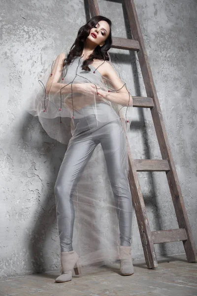 Beautiful girl in designer fashionable transparent clothes posing in studio. — Stock Photo, Image