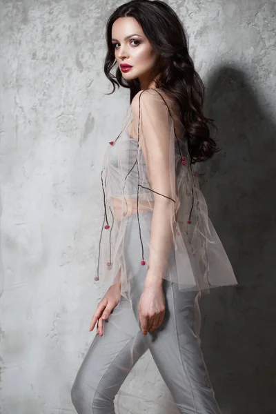 Schöne Mädchen in Designer modische transparente Kleidung posiert im Studio. — Stockfoto