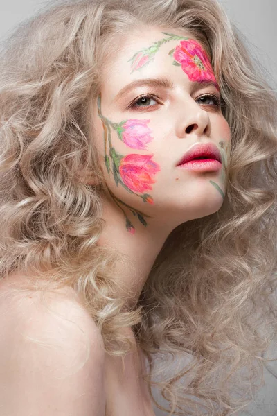 Mooi blond meisje met krullen en een floral patroon op het gezicht. Schoonheid bloemen. — Stockfoto