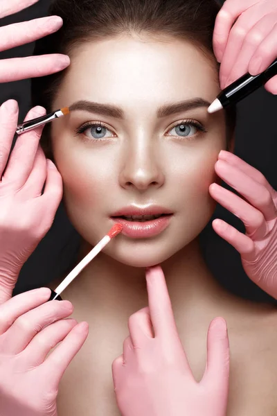 Beautiful young girl with natural nude make-up with cosmetic tools in hands. Beauty face. — Stock Photo, Image