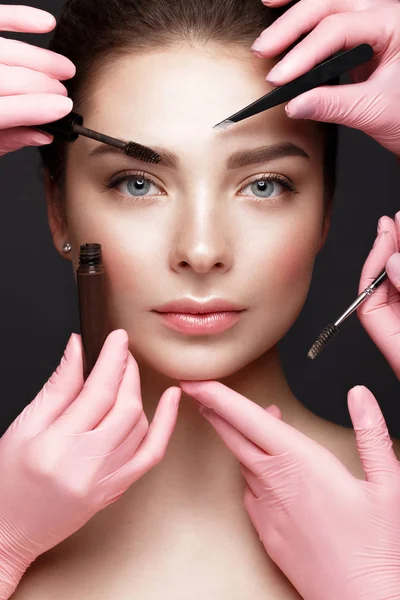 Beautiful young girl with natural nude make-up with cosmetic tools in hands. Beauty face. — Stock Photo, Image