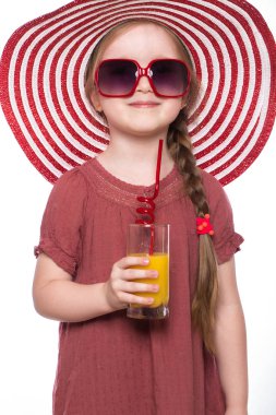 Elleri portakal suyu ile bir yaz panama, bir elbise, güneş gözlüğü, küçük bir kız.