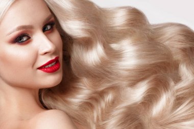 Güzel sarışın bir Hollywood şekilde bukleler, doğal makyaj ve kırmızı dudaklar. Güzellik ve saç.