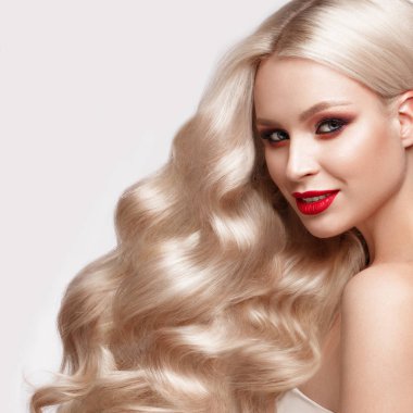 Güzel sarışın bir Hollywood şekilde bukleler, doğal makyaj ve kırmızı dudaklar. Güzellik ve saç.