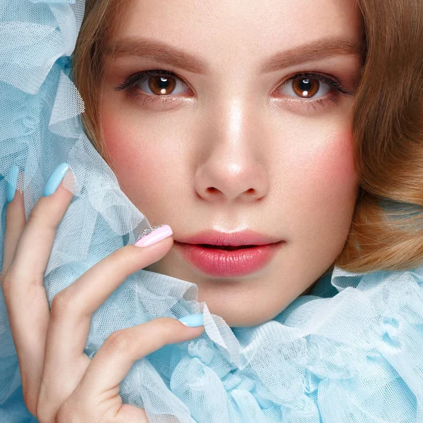 Vacker flicka med ljus make-up och mild manikyr i blå kläder. Skönhet ansikte. Design naglar. — Stockfoto