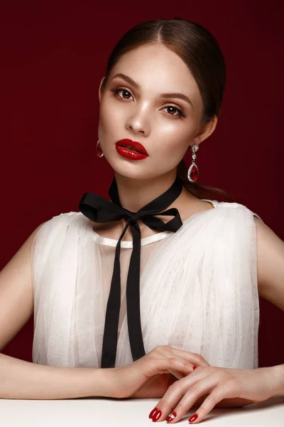 Gyönyörű lány fehér ruhában, klasszikus sminkkel és piros manikűrrel. Szépség arc. — Stock Fotó