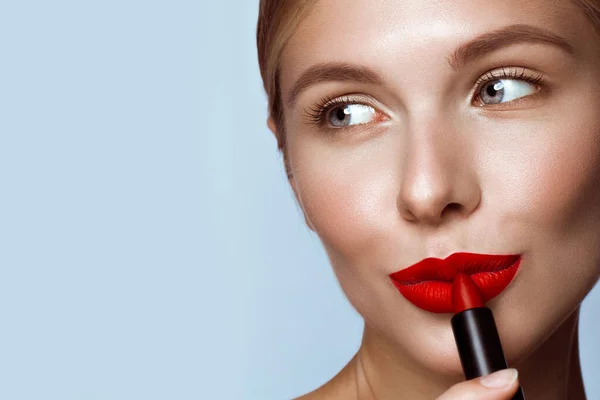 Beautiful girl with red lips and classic makeup with lipstick in hand. Beauty face — Stock Photo, Image