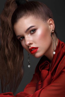 Klasik makyajlı, kırmızı elbiseli, pürüzsüz saçlı güzel bir kız. Güzel surat..