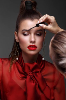 Klasik makyajlı, kırmızı elbiseli, pürüzsüz saçlı güzel bir kız. Güzel surat..