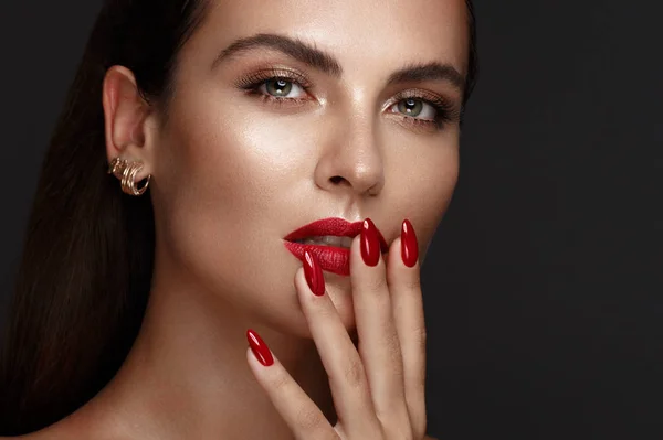 Όμορφο κορίτσι με ένα κλασικό make-up και κόκκινα νύχια. Μανικιούρ σχεδιασμού. Πρόσωπο ομορφιάς. — Φωτογραφία Αρχείου