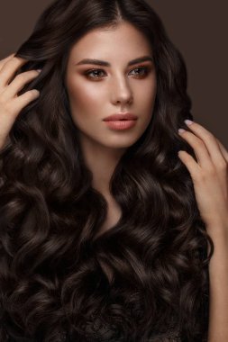 Güzel esmer model: bukleler, klasik makyaj ve dolgun dudaklar. Güzellik yüz.