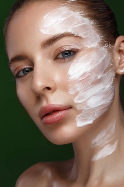 Yüzünde kozmetik kremi ve doğal makyajı olan güzel bir kız. Güzel surat..