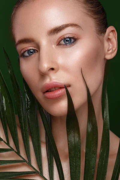 Bella ragazza fresca con pelle perfetta, trucco naturale e foglie verdi. Bellezza viso . — Foto Stock