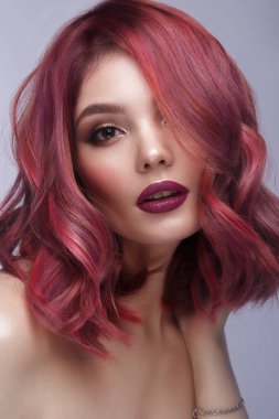 Çok renkli saçları, klasik makyajı ve saç stili olan güzel bir kız. Güzel surat..