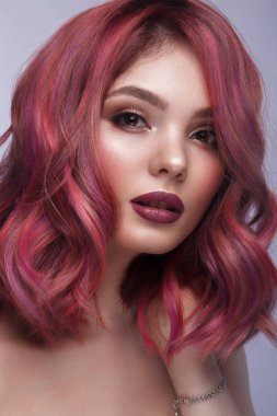 Çok renkli saçları, klasik makyajı ve saç stili olan güzel bir kız. Güzel surat..