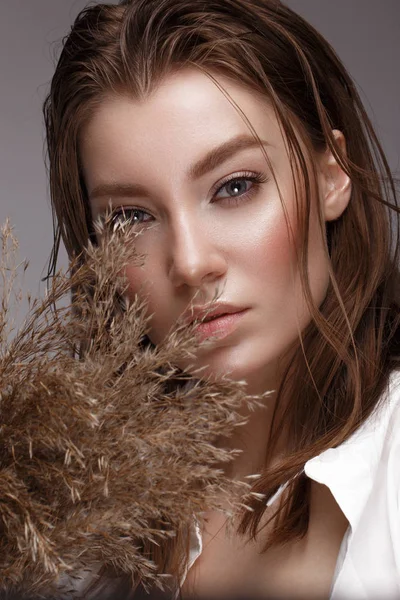 Mooie vrouw met klassieke naaktmake-up, licht kapsel en droge bloemen. Schoonheidsgezicht. — Stockfoto