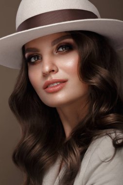 Beautiful sexy woman in a fashionable hat, with classic make-up, wave hair and smile. Beauty face.