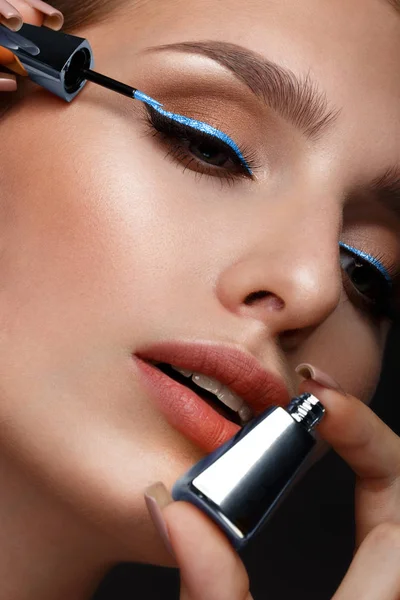 Beautiful girl with sexy lips and classic makeup with cosmetic blue eyeliner in hand. Beauty face. — Φωτογραφία Αρχείου