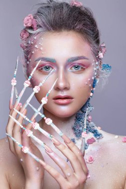 Sanat makyajlı ve uzun tırnaklı tatlı bir peri suretinde güzel bir kız. Yaratıcı manikür.