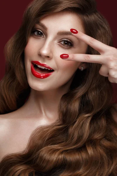 Menina bonita com uma maquiagem clássica, cabelos cachos e unhas vermelhas. Design de manicure. Cara de beleza . — Fotografia de Stock