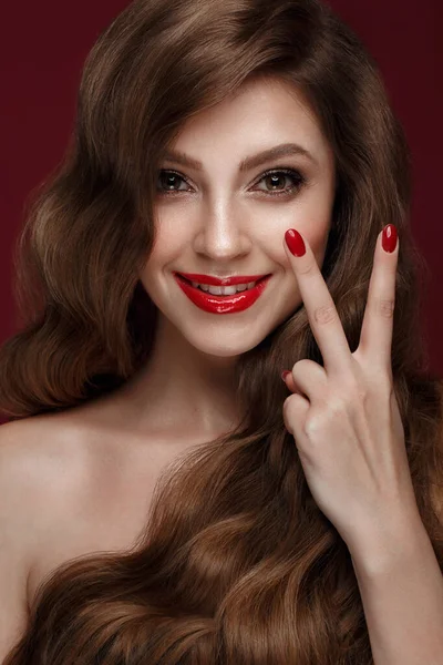 Hermosa chica con un maquillaje clásico, rizos de pelo y uñas rojas. Diseño de manicura. Cara de belleza . — Foto de Stock