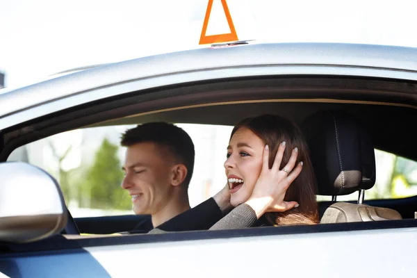 Driving instructor and woman student in examination car.