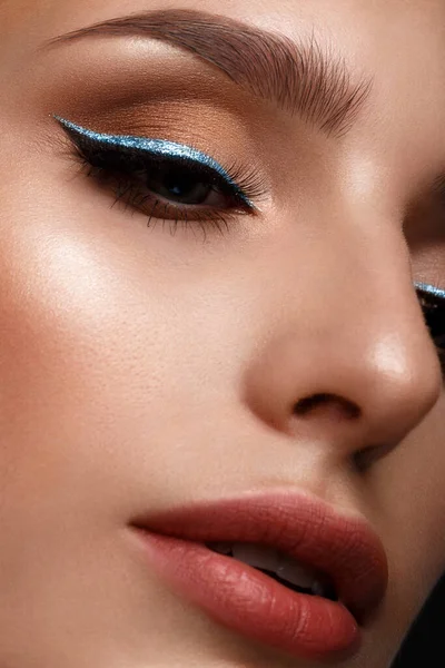 Όμορφο κορίτσι με σέξι χείλη και κλασικό μακιγιάζ με καλλυντικά μπλε eyeliner. Πρόσωπο ομορφιάς. — Φωτογραφία Αρχείου