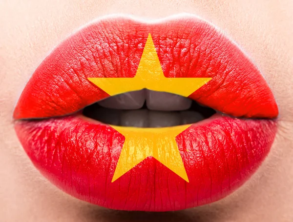 Женские губы закрываются фотографическим флагом Вьетнама. Красный, желтый . — стоковое фото