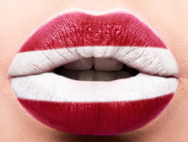 Les lèvres féminines se ferment avec un drapeau d'image de la Lettonie. blanc, rouge — Photo