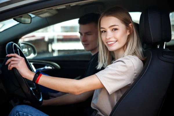 Driving instructor and woman student in examination car.