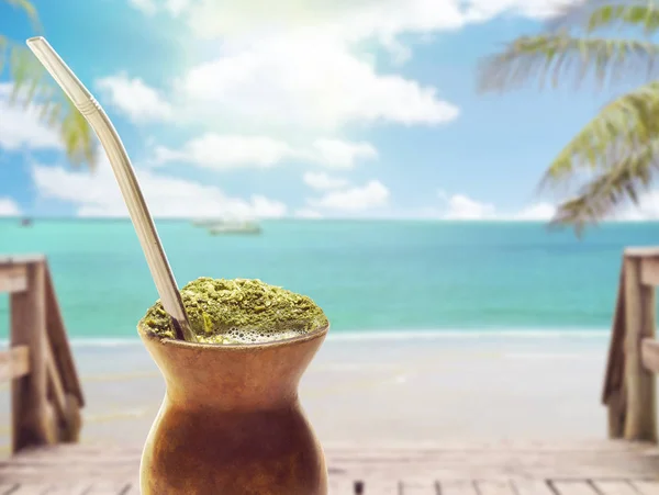 Chimarrao, tradicional mate de chá quente. Bebida do Sul do Brasil. Também conhecido como companheiro. Na praia tropical ensolarada paisagem fundo — Fotografia de Stock
