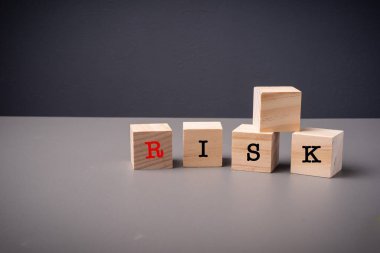 Gri arkaplana karşı istiflenmiş tahta küplerle ilgili RISK ifadeleri
