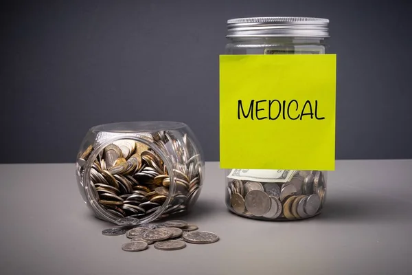 Medical saving concept. MEDICAL wordings on a paper sticked on a jar full of coins