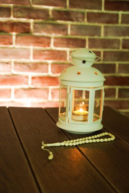 Kurban ve Ramadhan için İslami bir kavram. Tahta arka planda Tasbih (Tespih Boncukları) taşıyan geleneksel Arap feneri, Seçici Odak