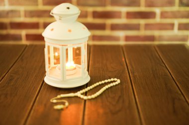 Kurban ve Ramadhan için İslami bir kavram. Tahta arka planda Tasbih (Tespih Boncukları) taşıyan geleneksel Arap feneri, Seçici Odak