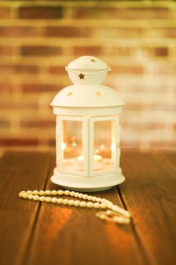 Kurban ve Ramadhan için İslami bir kavram. Tahta arka planda Tasbih (Tespih Boncukları) taşıyan geleneksel Arap feneri, Seçici Odak