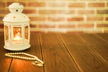 Kurban ve Ramadhan için İslami bir kavram. Tahta arka planda Tasbih (Tespih Boncukları) taşıyan geleneksel Arap feneri, Seçici Odak