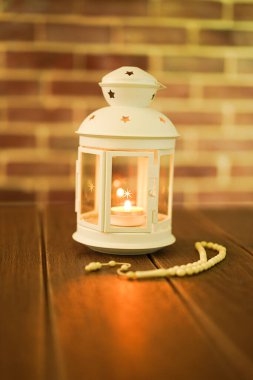 Kurban ve Ramadhan için İslami bir kavram. Tahta arka planda Tasbih (Tespih Boncukları) taşıyan geleneksel Arap feneri, Seçici Odak