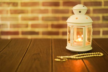 Kurban ve Ramadhan için İslami bir kavram. Tahta arka planda Tasbih (Tespih Boncukları) taşıyan geleneksel Arap feneri, Seçici Odak