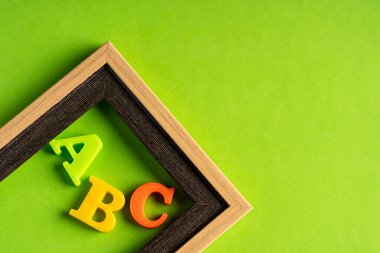 ABC ve boş fotoğraf çerçevesi yeşil arkaplan karşısında