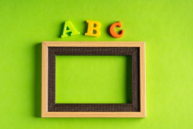 ABC ve boş fotoğraf çerçevesi yeşil arkaplan karşısında