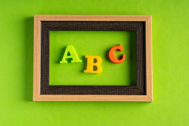 ABC ve boş fotoğraf çerçevesi yeşil arkaplan karşısında