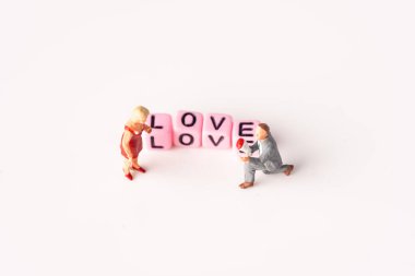 Aşk konsepti. Pembe arka planda minyatür çift