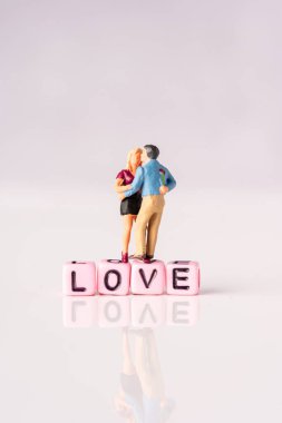 Aşk konsepti. Pembe arka planda minyatür çift