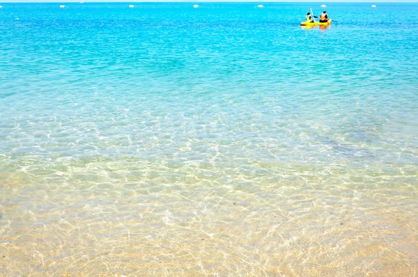 Temiz su ve güneş ışığı ile kum plajında denizin dalga 