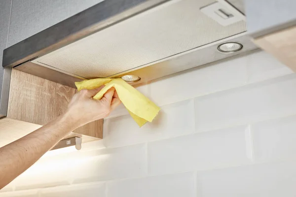 Ручне прибирання кухонної витяжки з жовтою мочалкою — стокове фото