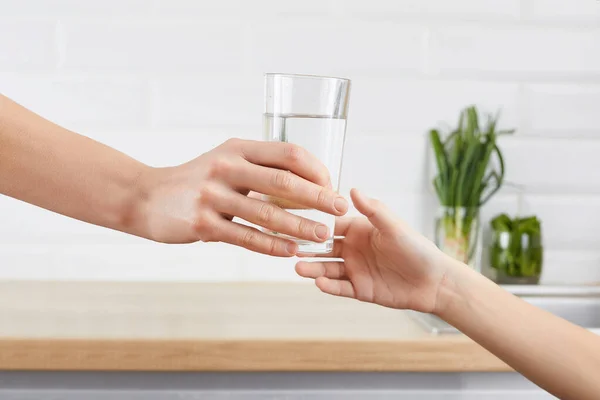 Mano delle donne dà un bicchiere di acqua purificata al suo bambino. Concetto depurazione dell'acqua — Foto Stock