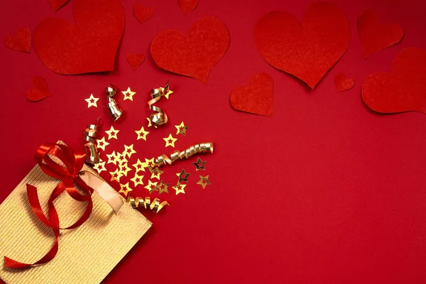 Concepto de fondo del Día de San Valentín. Fondo dulce de vacaciones con bolsa de regalo de oro, pequeñas estrellas sobre fondo de papel rojo . — Foto de Stock