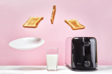 Tostlar modern tost makinesinden fırladı. Bir bardak sütün yanında. Havalandırma yiyeceği ve yemek. Lezzetli sabah kahvaltısı konsepti